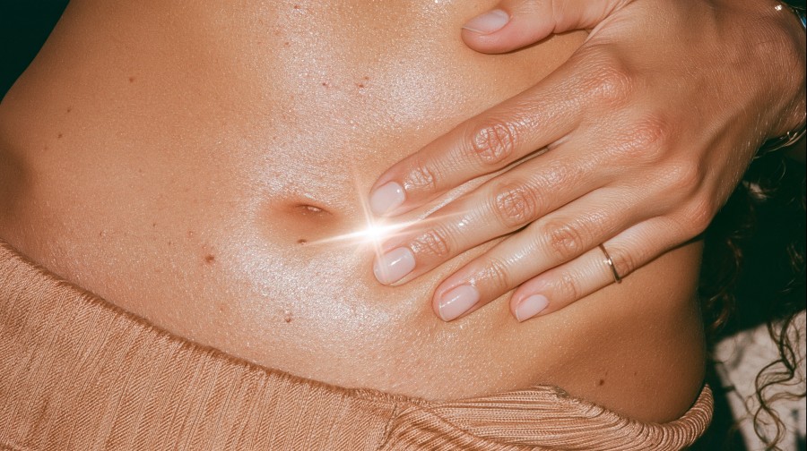 Hand resting on bare abdomen, illustrating the gut skin connection | North Skin Mona Vale