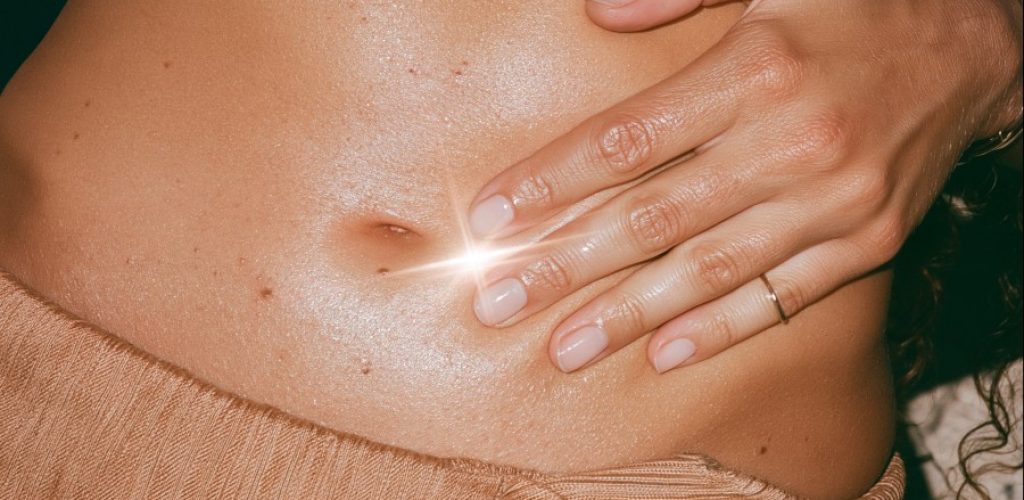 Hand resting on bare abdomen, illustrating the gut skin connection | North Skin Mona Vale